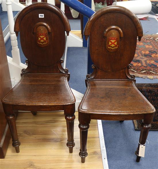 A pair of William IV oak hall chairs